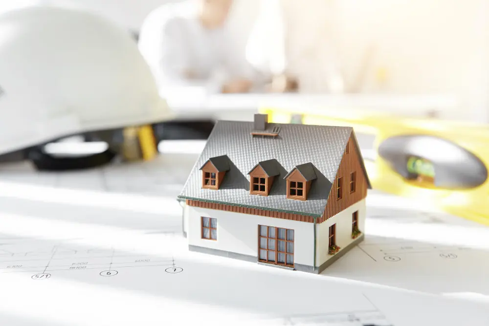 Maquette de maison posée sur des plans